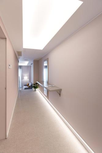 an empty room with white walls and a skylight at Teatro Romano Exclusive Suites in Trieste
