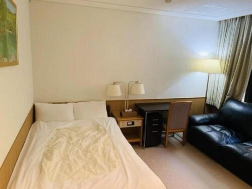 a hotel room with a bed and a couch at 箱根七福荘 in Onsensō