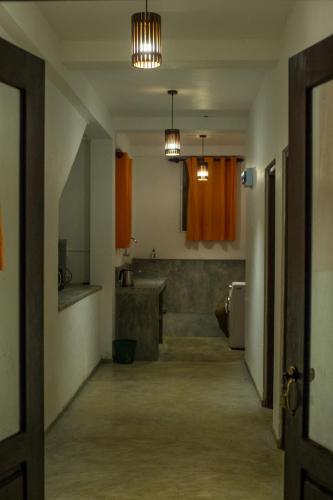 a hallway of a bathroom with a sink and a toilet at Sinharaja Hostel in Deniyaya