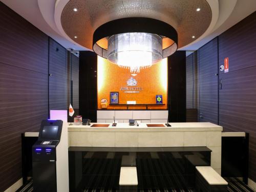 a lobby with a reception desk and a chandelier at APA Hotel Ikebukuro Eki Kitaguchi in Tokyo
