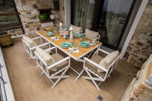 a dining room table with chairs and candles on it at Evmorfes Villas in Poligiros