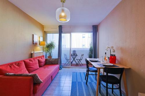 un salon avec un canapé rouge et une table dans l'établissement Joli appartement proche de la mer, au Pradet