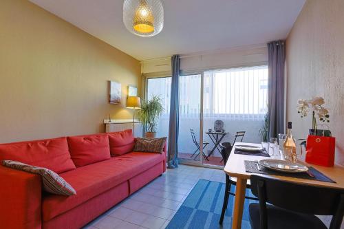 un salon avec un canapé rouge et une table dans l'établissement Joli appartement proche de la mer, au Pradet
