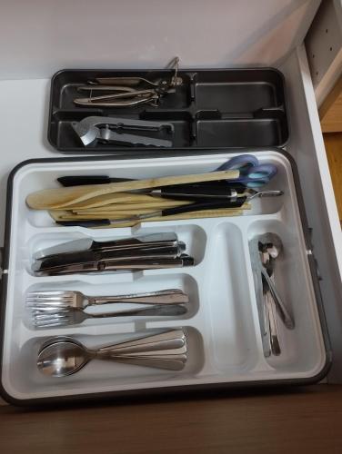 - un plateau blanc avec des ustensiles dans un tiroir dans l'établissement Apartement 2 rooms Saint Louis - Euroairport - Basel - Train station, à Saint-Louis