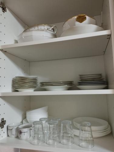 une armoire remplie de plats, de bols et de assiettes dans l'établissement Apartement 2 rooms Saint Louis - Euroairport - Basel - Train station, à Saint-Louis