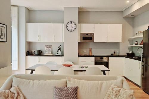 d'une cuisine et d'un salon avec une table et une horloge. dans l'établissement Charmant appartement T3 plein centre, à Luchon