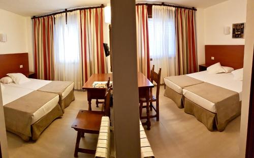 pokój hotelowy z dwoma łóżkami i stołem w obiekcie Hotel Torres Touriño w mieście Sanxenxo