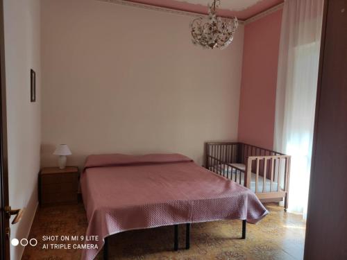 a bedroom with a bed and a chandelier at Nonna Sara Casa Vacanze in Patti