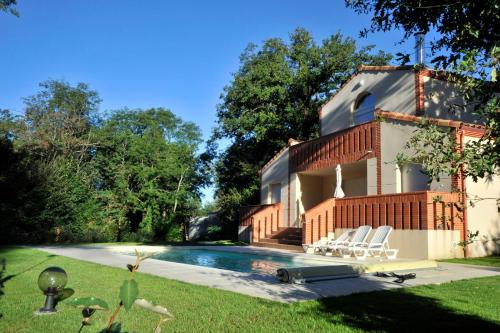 une maison avec une piscine dans la cour dans l'établissement Lagrange Vacances - Royal Green, à Pont-de-Larn