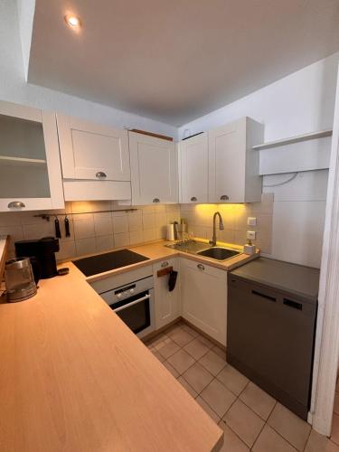 Una cocina con gabinetes blancos y un fregadero. en Heart of the Old City - Nice, en Niza