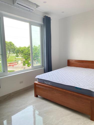 a bedroom with a bed and a large window at Tamcoc Motel in Văn Lâm