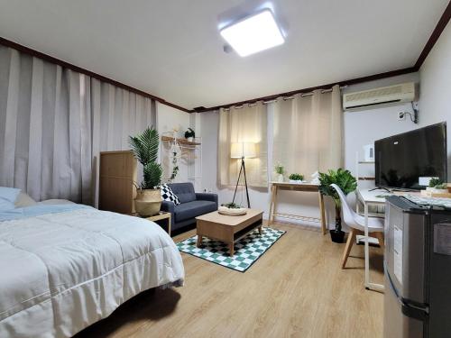 a bedroom with a bed and a desk and a tv at the stay Paju in Paju
