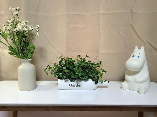 a table with two vases and a cat and a plant at the stay Paju in Paju