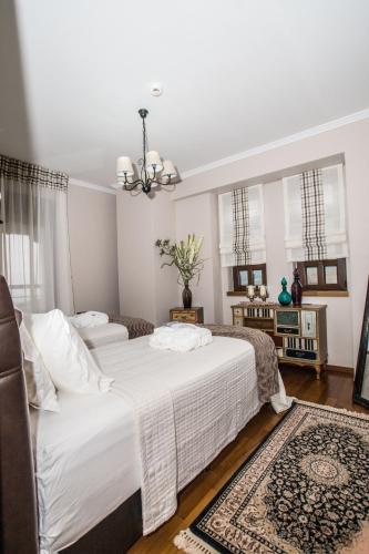 a bedroom with two beds and a chandelier at Evmorfes Villas in Poligiros