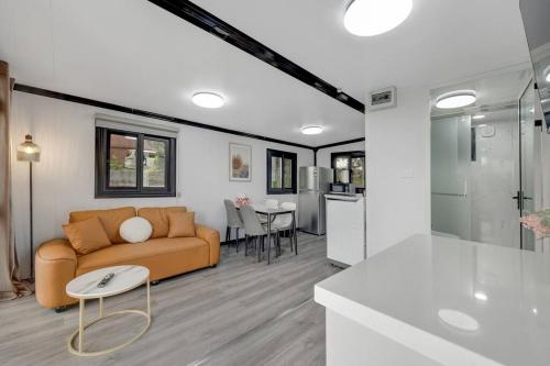 a living room with a couch and a table at 2 bedrooms Cabin 5 min to Pukekohe town centre in Pukekohe East