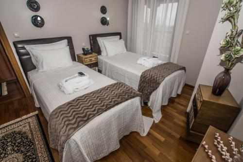 a hotel room with two beds with towels on them at Evmorfes Villas in Poligiros