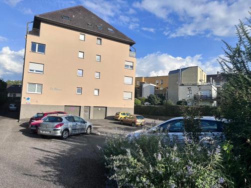 a large building with cars parked in a parking lot at Beau studio proche Strasbourg in Illkirch-Graffenstaden