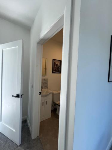 a white bathroom with a sink and a toilet at Deerpark 3 bed semi in Cashel