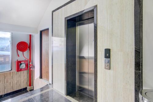 a glass elevator in a room with a red fire hydrant at Hotel Lokis Forest Inn L B Nagar in Surūrnagar