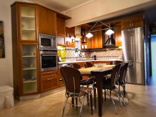 Una cocina con mesa y sillas y un refrigerador. en Διαμέρισμα στον Εύοσμο, en Tesalónica