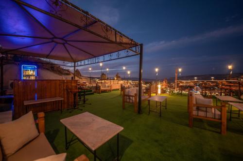 a patio with tables and chairs and lights at night at Roma Cave Suite in Goreme
