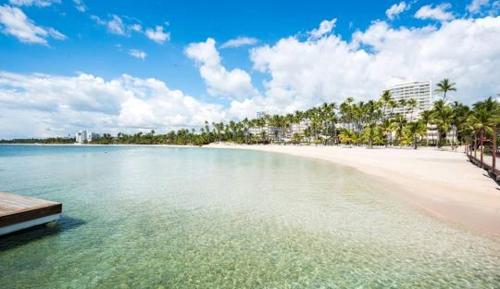 a view of a beach with a boat in the water at Dre Broeders Apartments Juan Dolio in Juan Dolio