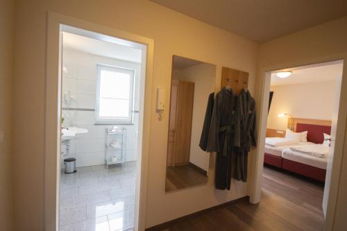 a room with a bathroom with a sink and a bed at Hotel Lipprandt in Wasserburg