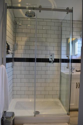 eine Dusche mit einer Glastür in einem Badezimmer in der Unterkunft Jasmine Cottage, Eamont Bridge in Penrith