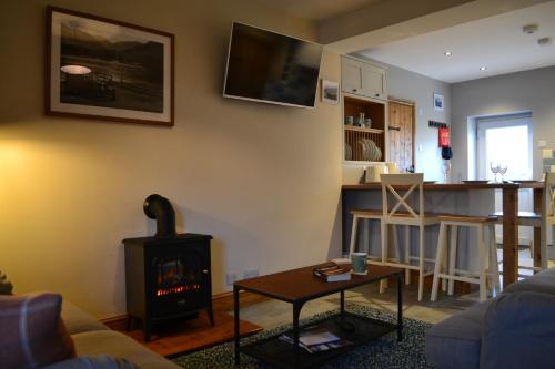 a living room with a fireplace and a stove at Jasmine Cottage, Eamont Bridge in Penrith
