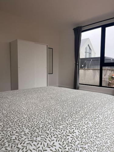 a bedroom with a large bed with a large window at Deerpark 3 bed semi in Cashel