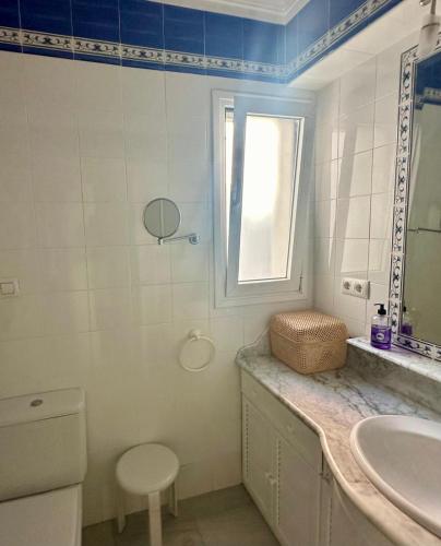 a bathroom with a sink and a toilet and a window at Ático horizonte in Sanlúcar de Barrameda
