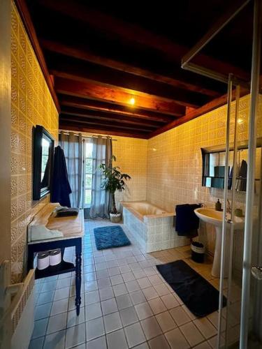 une salle de bain avec une baignoire et un lavabo dans l'établissement Le Relais de Chasse, à Clémont