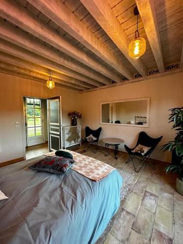 - une chambre avec un grand lit dans une pièce avec des chaises dans l'établissement Le Relais de Chasse, à Clémont