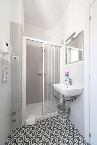 a white bathroom with a sink and a shower at Seven Rooms in San Benedetto del Tronto
