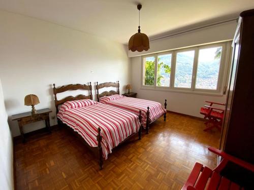 una camera con due letti con lenzuola a righe rosse e bianche di The Lemon Trees House a Lugano