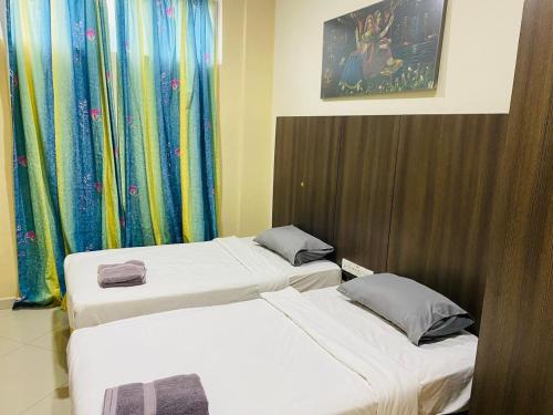 two beds in a hotel room with curtains at Kk INN HOTEL in Kuala Ampang