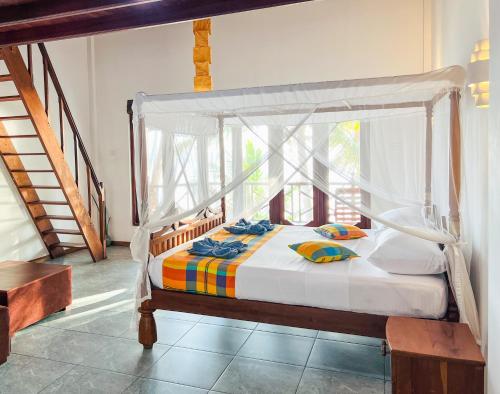 a bedroom with a bed with a canopy at Twenty- Two Swiss Residence in Weligama