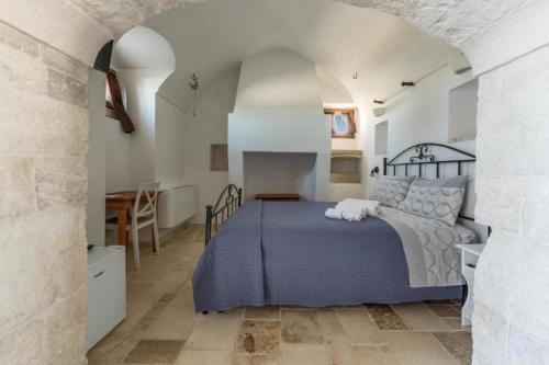 a bedroom with a bed and a table and a kitchen at Donna Teresa in Mottola