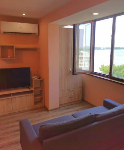 a living room with a couch and a flat screen tv at Danube View in Vidin