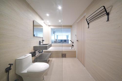 a bathroom with a toilet and a sink at Surf Beach House Pool Villa in Na Jomtien