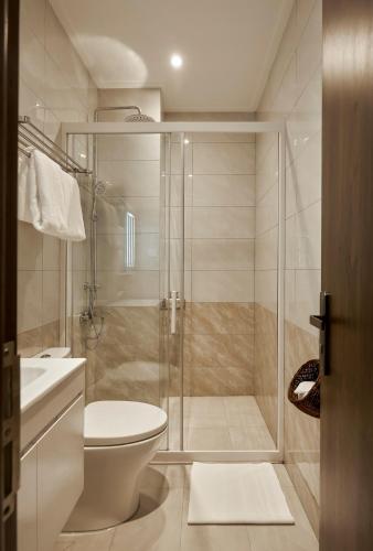a bathroom with a toilet and a glass shower at Chez Mimosa - Free Laundry in Ho Chi Minh City