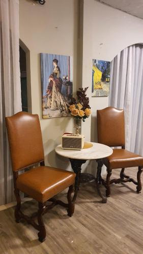 a room with a table with two chairs and a laptop on it at Style Jaritz in Ban Bang Phai