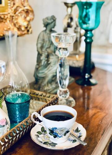 a cup of coffee on a table with a statue at Style Jaritz in Ban Bang Phai