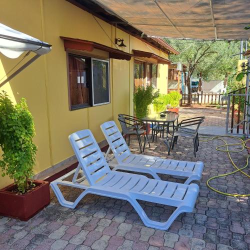 two blue lounge chairs and a table and a patio at For Nature Lovers in Skala Rachoniou