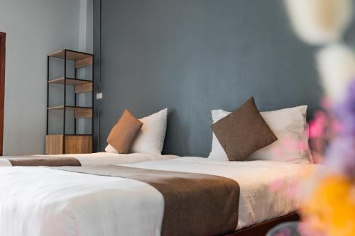 two beds with pillows in a room at A Hotel Cozy in Ban Pa Sak