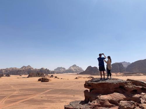 a couple standing on a rock in the desert at Wadi Rum The ARC camp in Wadi Rum