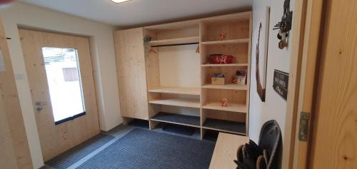 a room with a closet with shelves and a door at Yeti Lodge in Sedrun