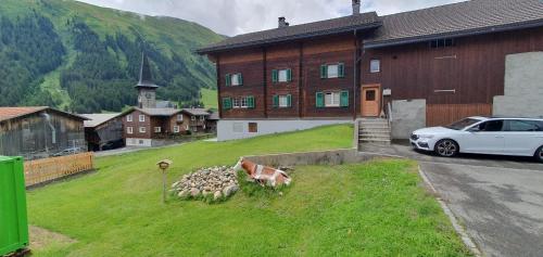 a herd of sheep in the grass in front of a house at Yeti Lodge in Sedrun