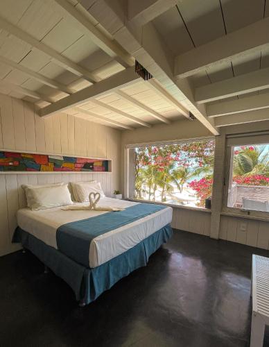 a bedroom with a large bed and a large window at Nordestina Loft in Icaraí