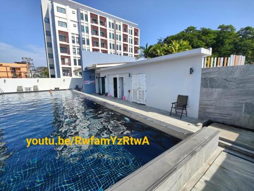 a swimming pool in front of a building at Blue and green Farang homes in Chiang Mai